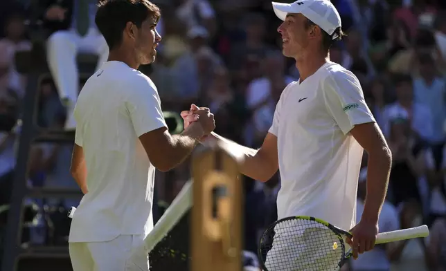 Carlos Alcaraz of Spain and Oliver Tarvet of Britain, right, ishake hands after their second round men's singles match at the Wimbledon Tennis Championships in London, Wednesday, July 2, 2025.(AP Photo/Kirsty Wigglesworth)
