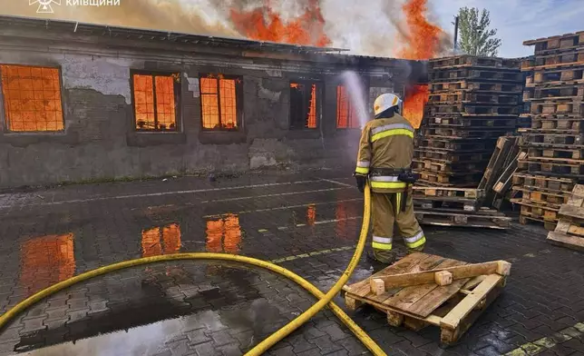 In this photo provided by the Ukrainian Emergency Service, a firefighter puts out the fire following a Russian attack in Kyiv region, Ukraine, Wednesday, July 9, 2025. (Ukrainian Emergency Service via AP)