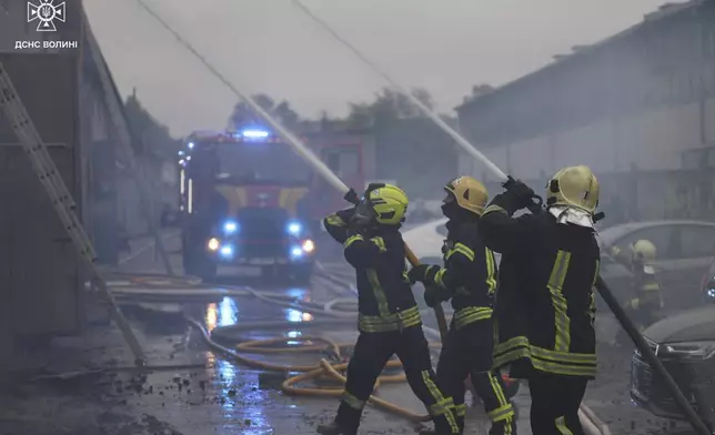 In this photo provided by the Ukrainian Emergency Service, firefighters put out the fire following a Russian attack in Volyn region, Ukraine, Wednesday, July 9, 2025. (Ukrainian Emergency Service via AP)