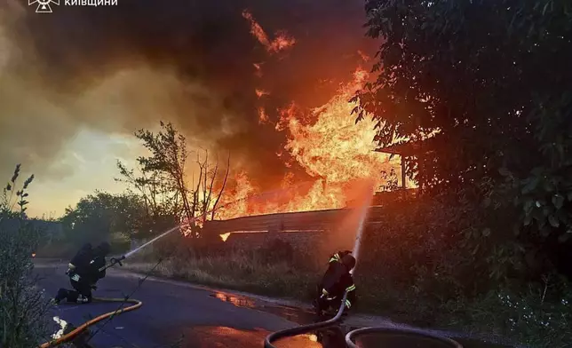 In this photo provided by the Ukrainian Emergency Service, firefighters put out the fire following a Russian attack in Kyiv region, Ukraine, Wednesday, July 9, 2025. (Ukrainian Emergency Service via AP)