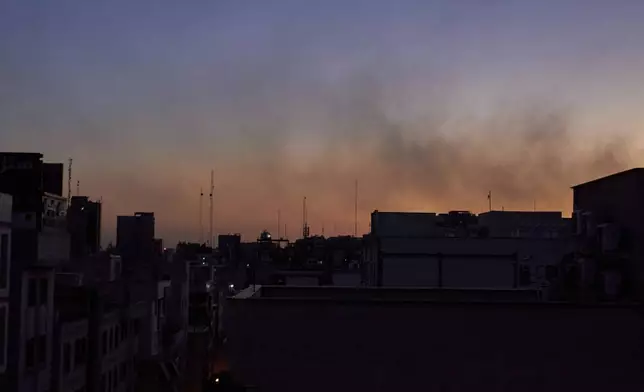 Smoke from earlier strikes hangs in the air at dusk during in Tehran, Iran, Wednesday, June 18, 2025. Many residents had evacuated, and those who stayed kept their homes and streetlights dim as a precaution. (AP Photo)