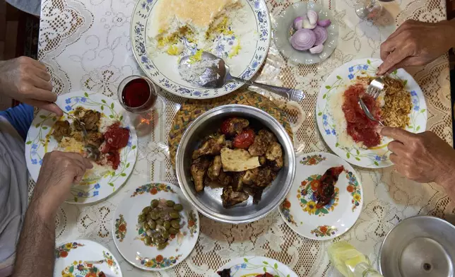 A family gathers for dinner in the town of Rasht, northwest of Tehran near the Caspian Sea, Friday, June 20, 2025, once considered safer than the capital. Midway through the war, three explosions shook the city, shattering its sense of safety. (AP Photo)