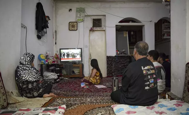 Nine-year-old Afghan girl Sara and her family watch the news about the ceasefire in silence in Tehran, Iran, Wednesday, June 25, 2025. They fled to Iran four years ago and now rarely leave the house, fearing arrest and deportation. (AP Photo)