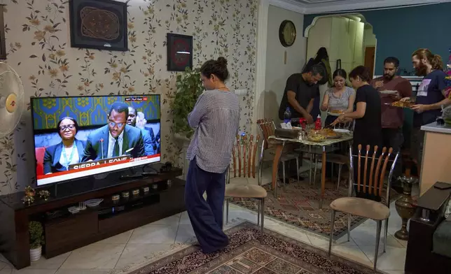 A group of friends gathers for dinner while following the TV for the latest updates on the Iran-Israel conflict in Tehran, Iran, on Monday, June 23, 2025. (AP Photo)