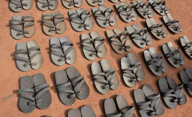 Footwear crafted from recycled rubber tires are displayed on the ground in Wau, South Sudan, Friday, June 13, 2025. (AP Photo/Michael Atit)