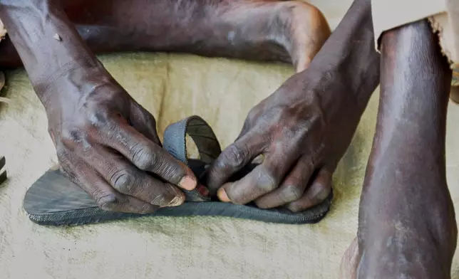 Shoemaker Emmanuel Achuil works on sandals in Wau, South Sudan, Friday, June 13, 2025. (AP Photo/Michael Atit)