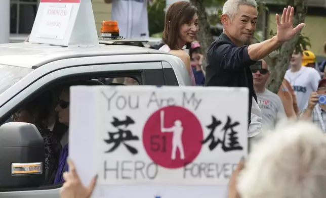 Baseball Hall of Fame inductee Ichiro Suzuki, right, and his wife Yumiko Suzuki smile during the Baseball Hall of Fame Parade of Legends in Cooperstown, N.Y., Saturday, July 26, 2025. (AP Photo/Seth Wenig)
