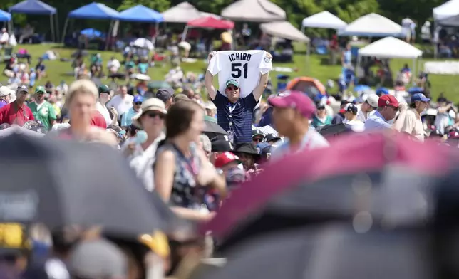 A man holds up an Ichiro Suzuki jersey before the National Baseball Hall of Fame induction ceremony in Cooperstown, N.Y., Sunday, July 27, 2025. (AP Photo/Seth Wenig)