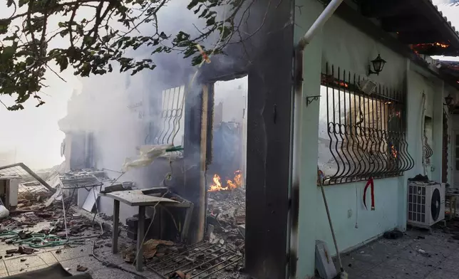 Blazes burn a house during a wildfire, in the northwestern suburb of Kryoneri, in Athens, Greece, Saturday, July 26, 2025. (AP Photo/Yorgos Karahalis)