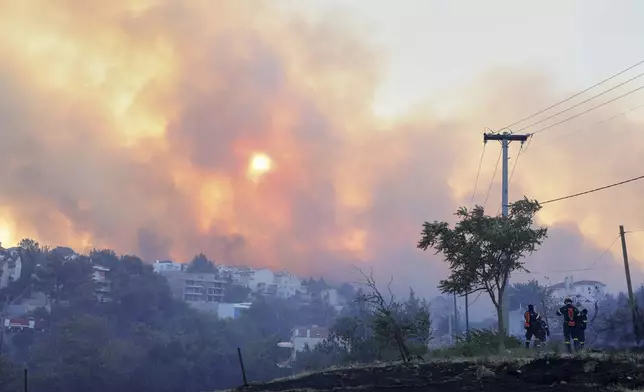 Smoke covers the sky during a wildfire, in the northwestern suburb of Kryoneri, in Athens, Greece, Saturday, July 26, 2025. (AP Photo/Yorgos Karahalis)