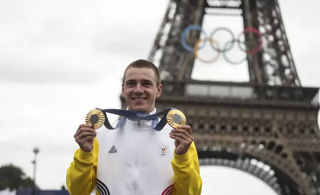 FILE - Remco Evenepoel, of Belgium, shows his gold medals of the men's time trial and road cycling events, at the 2024 Summer Olympics, Saturday, Aug. 3, 2024, in Paris, France. (AP Photo/Thibault Camus, File)