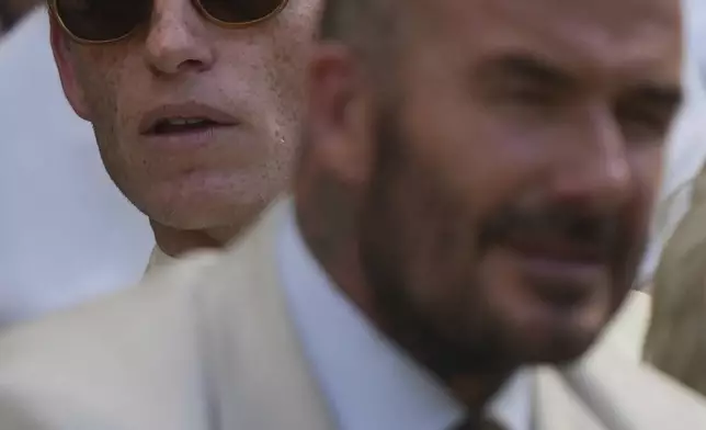 Actor Eddie Redmayne, rear, and Sir David Beckham sit in the Royal Box on Centre Court on day one at the Wimbledon Tennis Championships in London, Monday, June 30, 2025. (AP Photo/Alastair Grant)