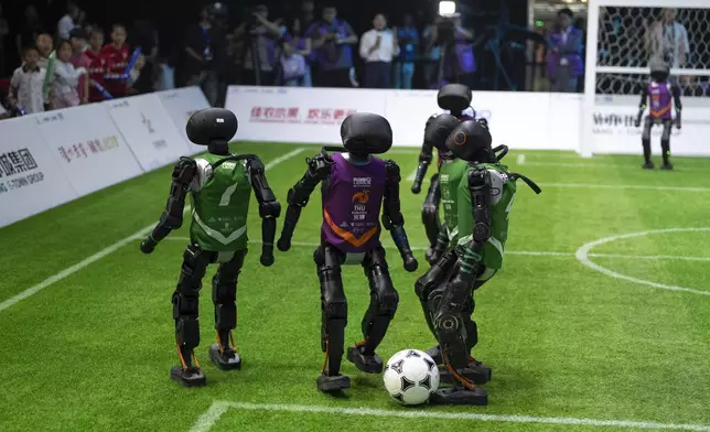 Teams using autonomous T1 robots from Booster Robotics compete in the inaugural RoBoLeague robot soccer competition held in Beijing, Saturday, June 28, 2025. (AP Photo/Ng Han Guan)