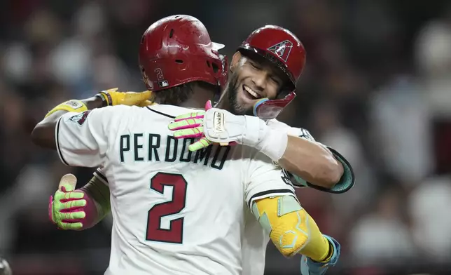 Arizona Diamondbacks' Lourdes Gurriel Jr., right, celebrates his two-run home run against the San Diego Padres with Diamondbacks' Geraldo Perdomo (2) during the eighth inning of a baseball game Tuesday, Aug. 5, 2025, in Phoenix. (AP Photo/Ross D. Franklin)
