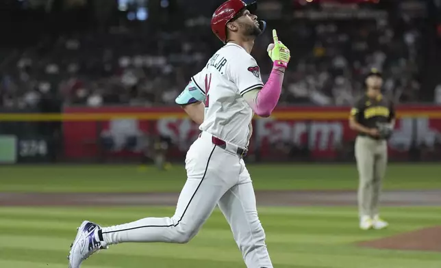 Arizona Diamondbacks' Lourdes Gurriel Jr., left, looks up as he rounds the bases after hitting a two-run home run against San Diego Padres starting pitcher Yu Darvish, right, of Japan, during the first inning of a baseball game Tuesday, Aug. 5, 2025, in Phoenix. (AP Photo/Ross D. Franklin)