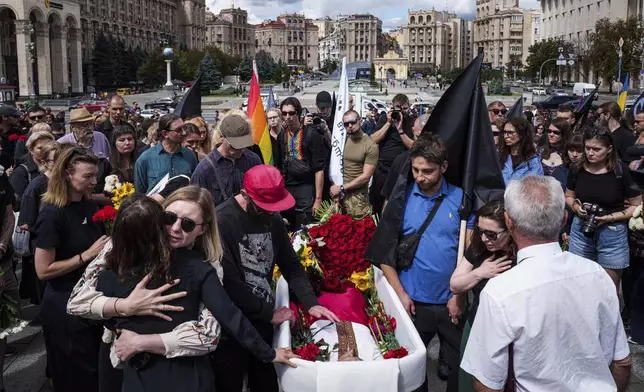 People say goodbye to David Chichkan, a Ukrainian serviceman and artist during his farewell ceremony at Independence square in Kyiv, Ukraine, on Monday, Aug. 18, 2025. (AP Photo/Evgeniy Maloletka)