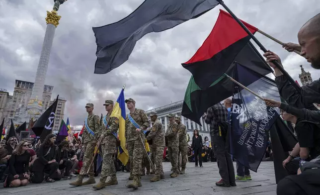 Honor Guards carry the coffin of David Chichkan, a Ukrainian serviceman and artist during a farewell ceremony at Independence square in Kyiv, Ukraine, on Monday, Aug. 18, 2025. (AP Photo/Evgeniy Maloletka)