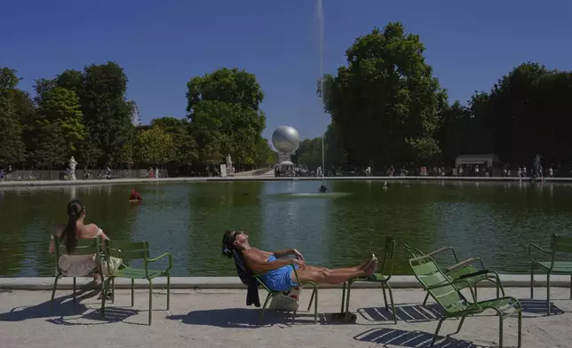 A man sunbaths in the Tuileries gardens, Monday, Aug. 11, 2025 in Paris. (AP Photo/Aurelien Morissard)