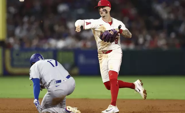 Los Angeles Angels shortstop Zach Neto (9) throws to first base to complete a double play as Los Angeles Dodgers designated hitter Shohei Ohtani (17) slides into second base during the sixth inning of a baseball game, Monday, Aug. 11, 2025, in Anaheim, Calif. (AP Photo/Jessie Alcheh)