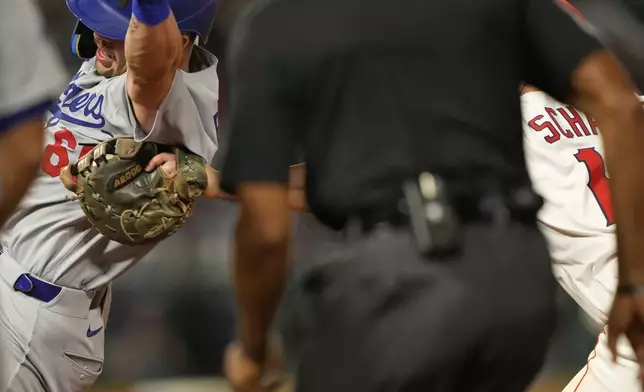Los Angeles Dodgers' Dalton Rushing, left, is tagged out by Los Angeles Angels first baseman Nolan Schanuel for the last out of a triple play during the sixth inning of a baseball game Tuesday, Aug. 12, 2025, in Anaheim, Calif. (AP Photo/Mark J. Terrill)