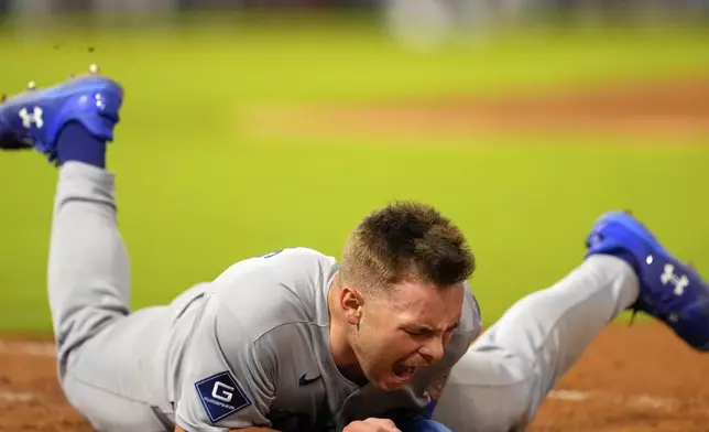 Los Angeles Dodgers' Dalton Rushing this the ground after being tagged out in the last out of a triple play during the sixth inning of a baseball game Tuesday, Aug. 12, 2025, in Anaheim, Calif. (AP Photo/Mark J. Terrill)