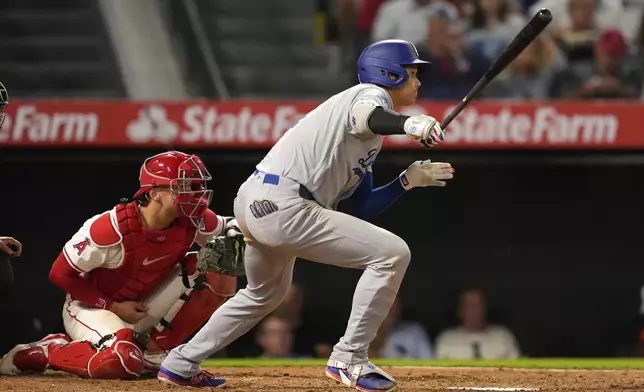 Los Angeles Dodgers' Shohei Ohtani, right, hits into a triple play as Los Angeles Angels catcher Logan O'Hoppe watches during the sixth inning of a baseball game Tuesday, Aug. 12, 2025, in Anaheim, Calif. (AP Photo/Mark J. Terrill)