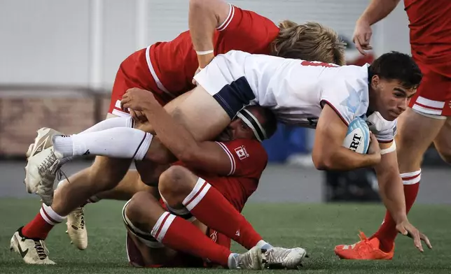United States' Dominic Besag, front right, is tackled by Canada's Nic Benn and Tyler Ardron during second-half Pacific Nations Cup rugby match action in Calgary, Alberta, Friday, Aug. 22, 2025. (Jeff McIntosh/The Canadian Press via AP)