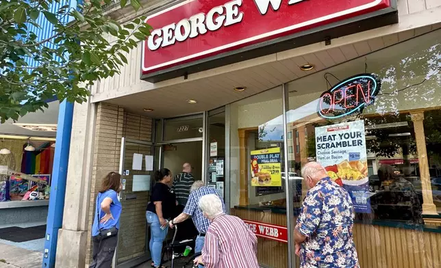 Fans line up outside a George Webb restaurant in Milwaukee, Wednesday, Aug. 20, 2025, to capitalize on a giveaway by the local fast-food chain, which gives out free hamburgers whenever the Milwaukee Brewers win at least 12 straight games. (AP Photo/Steve Megargee)