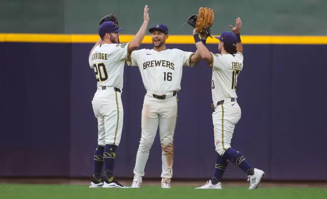 Milwaukee Brewers' Brandon Lockridge (20) Blake Perkins (16) and Sal Frelick (10) react after beating the Pittsburgh Pirates in a baseball game, Wednesday, Aug. 13, 2025, in Milwaukee. (AP Photo/Jeffrey Phelps)