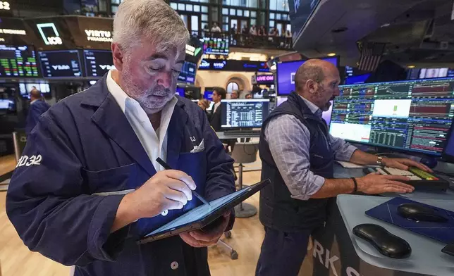 Trader Edward McCarthy, left, and specialist James Denaro work on the floor of the New York Stock Exchange, Wednesday, Aug. 13, 2025. (AP Photo/Richard Drew)