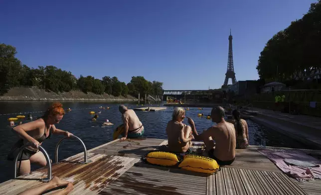 People enjoy the sun after a swim in the Seine river, Monday, Aug. 11, 2025 in Paris. (AP Photo/Aurelien Morissard)