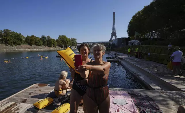 Women take a selfie after a swim in the Seine river, Monday, Aug. 11, 2025 in Paris. (AP Photo/Aurelien Morissard)