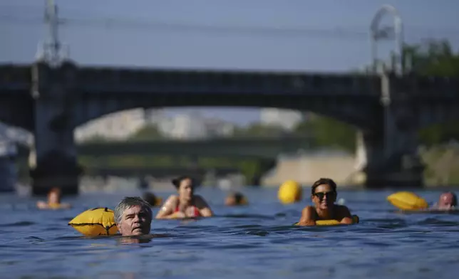 People swim in the Seine river, Monday, Aug. 11, 2025 in Paris. (AP Photo/Aurelien Morissard)