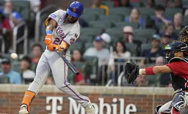 New York Mets' Cedric Mullins (28) hits a triple in the third inning of a baseball game against the Atlanta Braves, Friday, Aug. 22, 2025, in Atlanta. (AP Photo/Brynn Anderson)