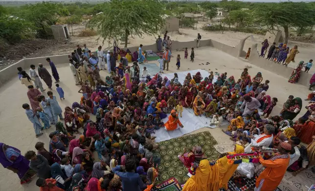 Villagers watch a performance of a Pakistani folk musician Sham Bhai at a village in Umerkot, a district of Pakistan's southeastern Sindh province, Thursday, July 17, 2025. (AP Photo/Fareed Khan)