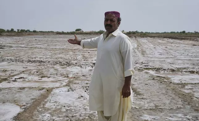 Farmer Ghulam Mustafa Mahar talks about his land, where subsoil water had risen to the surface, at a village in Umerkot, a district of Pakistan's southeastern Sindh province, Thursday, July 17, 2025. (AP Photo/Fareed Khan)