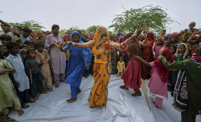 Women dance during a performance of a Pakistani folk musician Sham Bhai at a village in Umerkot, a district of Pakistan's southeastern Sindh province, Thursday, July 17, 2025. (AP Photo/Fareed Khan)