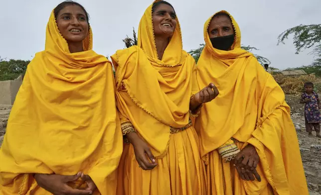 Pakistani folk musician Sham Bhai, center, arrives with her team members for her performance at a village in Umerkot, a district of Pakistan's southeastern Sindh province, Thursday, July 17, 2025. (AP Photo/Fareed Khan)
