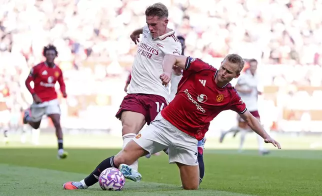 Arsenal's Viktor Gyokeres, centre, and Manchester United's Matthijs de Ligt battle for the ball during the English Premier League soccer match between Manchester United and Arsenal at Old Trafford stadium in Manchester, England, Sunday, Aug. 17, 2025. (Nick Potts/PA via AP)
