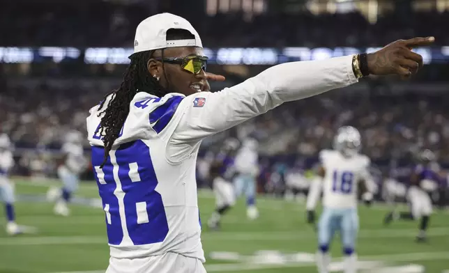 Dallas Cowboys' CeeDee Lamb celebrates a first down as he watches play from the sideline in the second half of a preseason NFL football game against the Baltimore Ravens Saturday, Aug. 16, 2025, in Arlington, Texas. (AP Photo/Gareth Patterson)