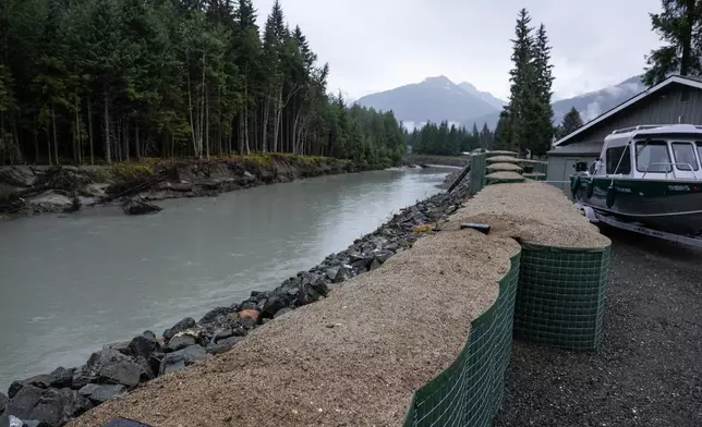 HESCO flood barriers, to protect property against glacial outburst flooding, separate a residential area from the Mendenhall River, Sunday, Aug. 3, 2025., in Juneau, Alaska. (Marc Lester/Anchorage Daily News via AP)
