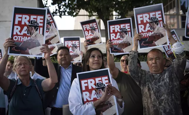 Dr. Wafaa Alrashid, center, whose husband, Rami Othmane, a Tunisian musician, is detained at the U.S. Immigration and Customs Enforcement facility, is joined by supporters during a rally outside the facility in Los Angeles Friday, July 25, 2025. (AP Photo/Jae C. Hong)