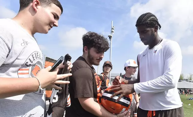 Cleveland Browns quarterback Shedeur Sanders, right, signs autographs after a practice at the team's NFL football training camp Saturday, July 26, 2025, in Berea, Ohio. (AP Photo/David Richard)