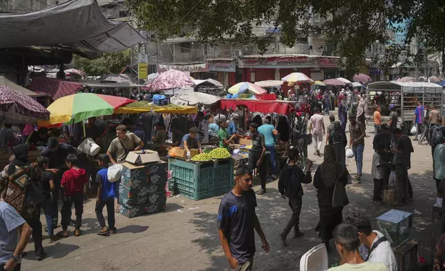 Palestinians shop at a makeshift market in Deir al-Balah, central Gaza Strip, Monday, Aug. 11, 2025. (AP Photo/Abdel Kareem Hana)