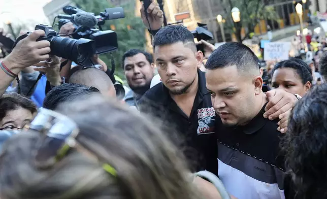 Kilmar Abrego Garcia, right, and his brother Cesar Abrego Garcia, center, arrive at the Immigration and Customs Enforcement field office in Baltimore, Monday, Aug. 25, 2025. (AP Photo/Stephanie Scarbrough)