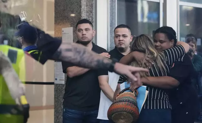 Kilmar Abrego Garcia, center, and his brother Cesar Abrego Garcia, left, arrive at the Immigration and Customs Enforcement field office in Baltimore, Monday, Aug. 25, 2025. (AP Photo/Stephanie Scarbrough)