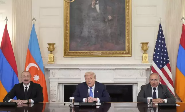 President Donald Trump, center, sits during a trilateral signing with Azerbaijan's President Ilham Aliyev, left, and Armenia's Prime Minister Nikol Pashinyan in the State Dining Room of the White House, Friday, Aug. 8, 2025, in Washington. (AP Photo/Mark Schiefelbein)