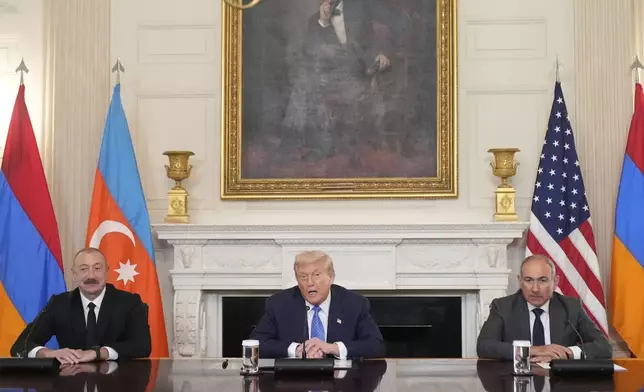 President Donald Trump, center, sits during a trilateral signing with Azerbaijan's President Ilham Aliyev, left, and Armenia's Prime Minister Nikol Pashinyan in the State Dining Room of the White House, Friday, Aug. 8, 2025, in Washington. (AP Photo/Mark Schiefelbein)