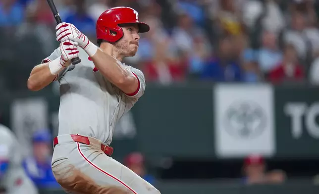 Philadelphia Phillies' Max Kepler follows through on a two-run double against the Texas Rangers during the seventh inning of a baseball game Saturday, Aug. 9, 2025, in Arlington, Texas. (AP Photo/Julio Cortez)