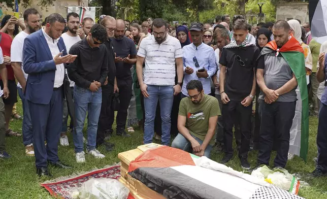 Mourners gather around the coffin of 19-year-old Palestinian woman Marah Abu Zhuri during her funeral in Pontesserchio, near Pisa, Italy, Wednesday Aug. 20, 2025, who died there after being evacuated from Gaza. (Alessandro La Rocca/LaPresse via AP)
